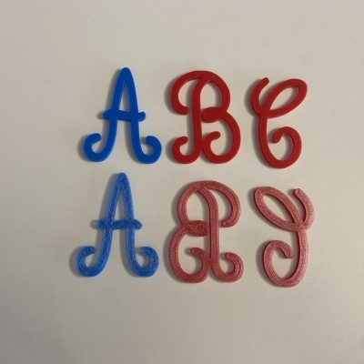 Letras plásticas coloridas azul e vermelho em superfície branca