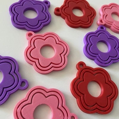 Flores de silicone coloridas em roxo, vermelho e rosa sobre superfície branca