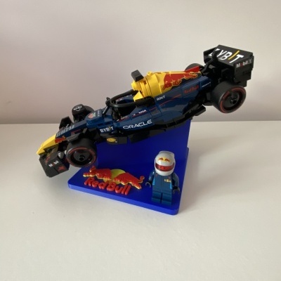 Miniatura de carro de Fórmula 1 e figura em miniatura da Red Bull Racing numa base azul