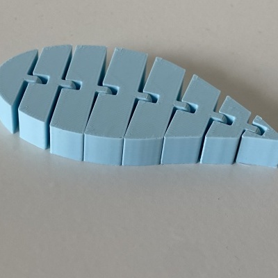 Peça de plástico azul clara segmentada em forma de peixe