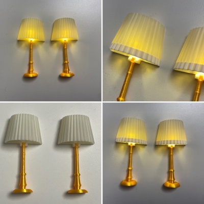 duas lâmpadas de mesa douradas com abajur branco iluminadas