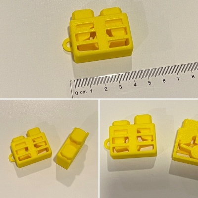 Conjunto de peças amarelas de plástico com aberturas, ao lado de uma régua em centímetros