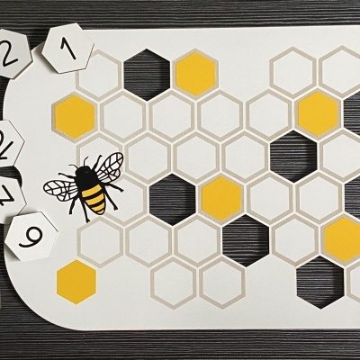 Jogo de tabuleiro com padrão de colmeia e peças numeradas ao lado