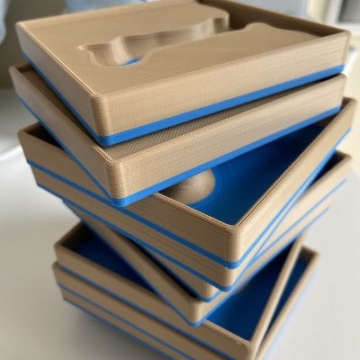 Pilhas de caixas de plástico bege e azul com tampas moldadas sobre superfície branca