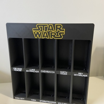 Organizador de plástico preto com divisórias para personagens Star Wars e nomes impressos.