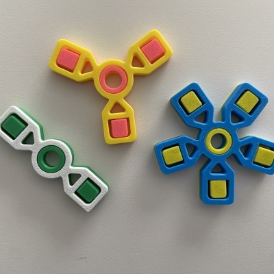 Três spinners coloridos em plástico sobre fundo branco