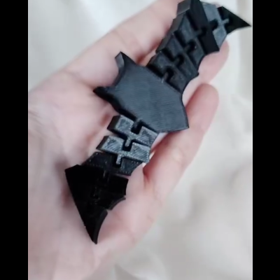 Objeto preto pequeno segurado numa mão