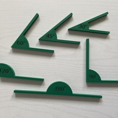 Conjunto de seis esquadros plásticos verdes com diferentes ângulos marcados sobre superfície clara