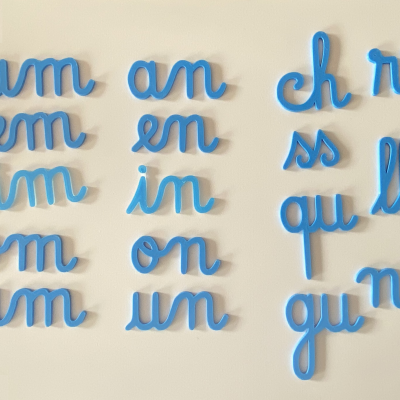 Letras cursivas azuis em grupos bilíteros sobre superfície branca