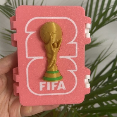 Caixa rosa com troféu dourado e texto FIFA