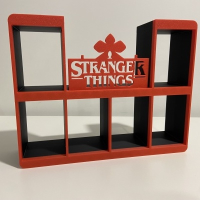 Organizador de plástico vermelho com texto STRANGER THINGS e compartimentos em preto