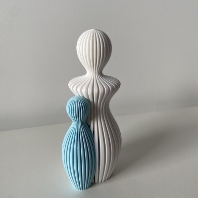 Duas figuras decorativas estilizadas, branca e azul clara