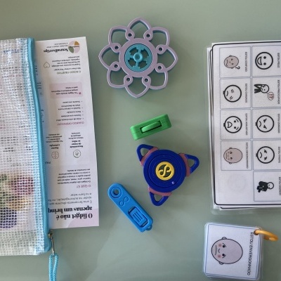 Kit de brinquedos fidget com bolsa transparente, brinquedos sensoriais coloridos e cartas de emoções plastificadas.
