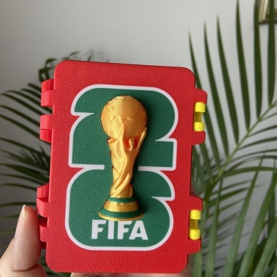 Caixa vermelha com o troféu da FIFA em relevo dourado e texto FIFA