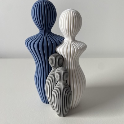 Esculturas abstratas de figuras humanas azuis, branca e cinzas com linhas verticais onduladas