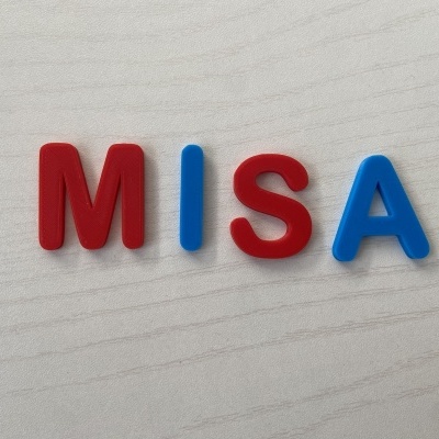 Letras de plástico vermelhas e azuis formando a palavra MISA