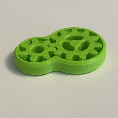 Peça verde de plástico com duas engrenagens interligadas