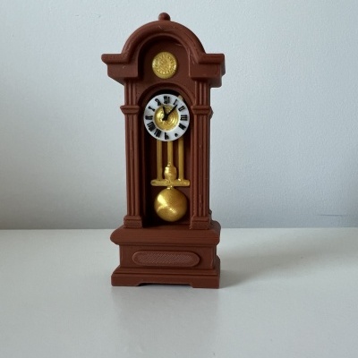 Relógio de pêndulo castanho com detalhes dourados e mostrador branco com números romanos