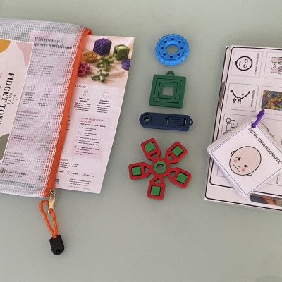 Kit de brinquedos Fidget Toys coloridos com saco transparente e cartões ilustrados.
