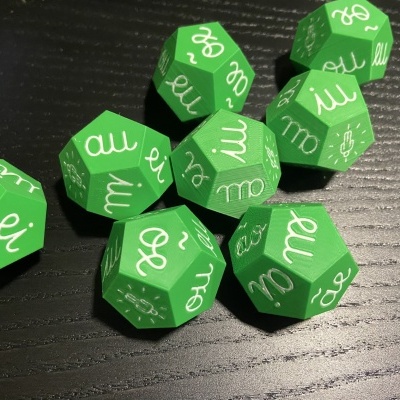 Dados verdes com símbolos brancos numa mesa preta