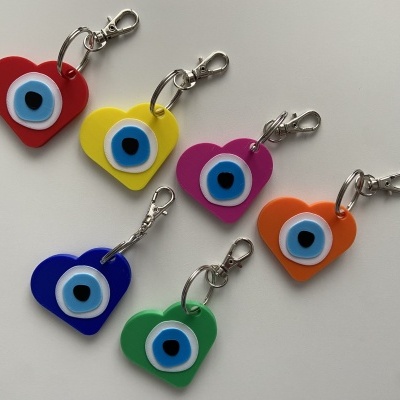 Chaveiros em forma de coração com olho grego coloridos sobre fundo branco