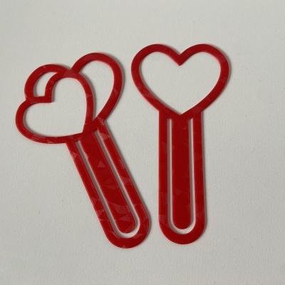 Dois marcadores de página vermelhos com formato de coração em fundo branco