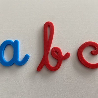 Três imãs coloridos em forma das letras a, b e c