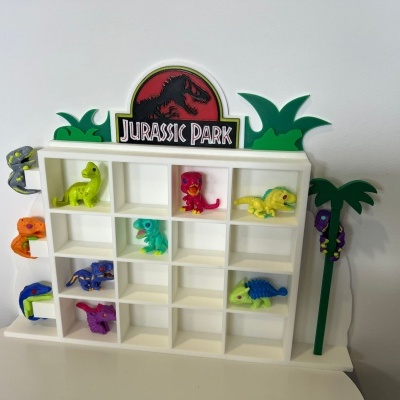 Estante branca de brinquedo decorada com logo Jurassic Park e dinossauros coloridos de brinquedo