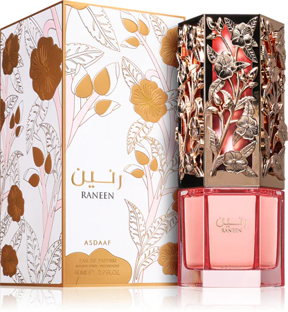Frasco rosa de perfume com tampa decorativa dourada e embalagem com ilustrações florais