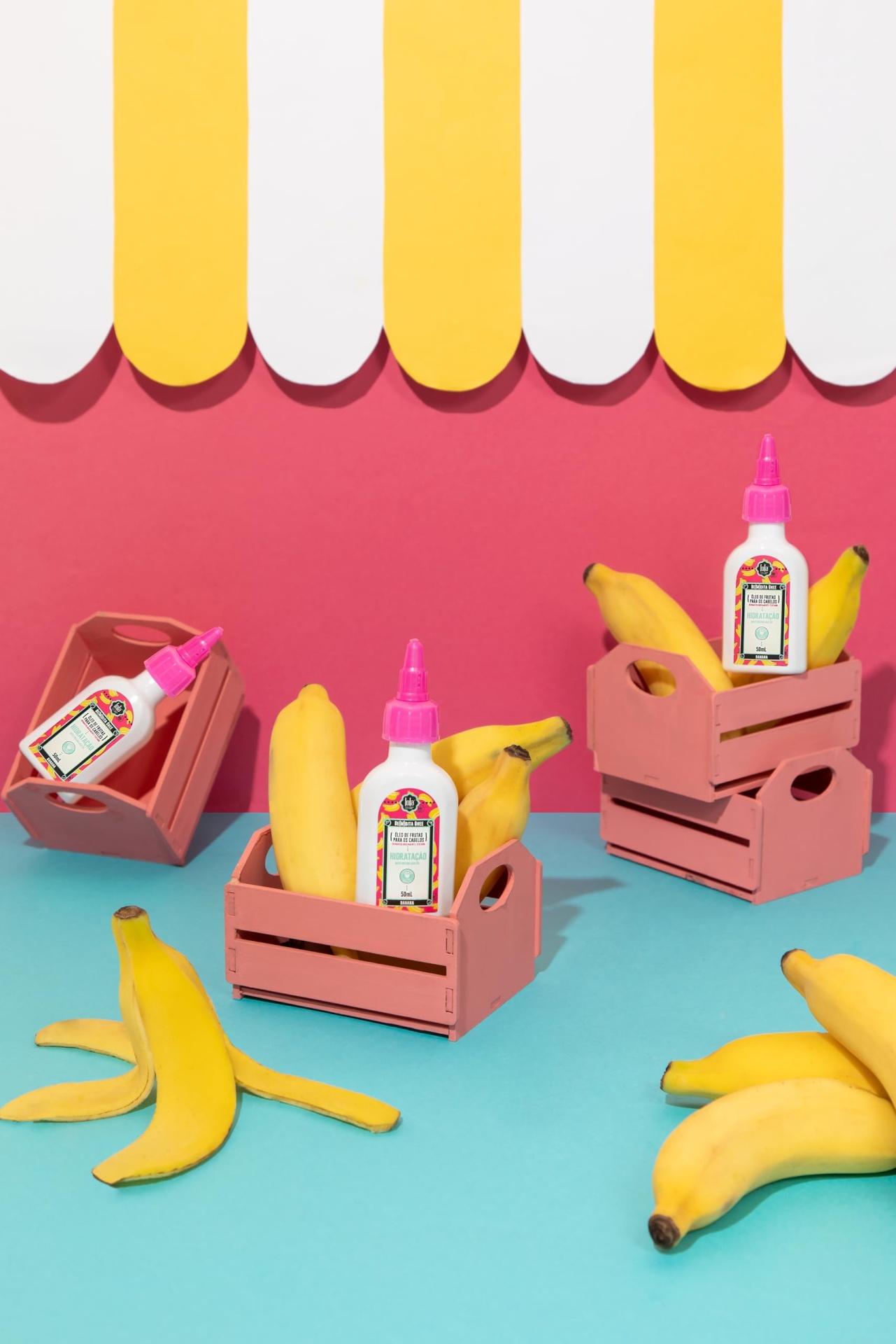 Mini caixas de madeira com bananas e frascos de cola branca em fundo colorido