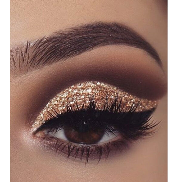 Olho maquilhado com sombra dourada brilhante e delineador preto