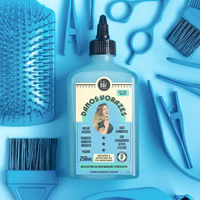 Frasco azul claro de produto capilar DAÑOS DORAZLES entre acessórios de cabelo azuis