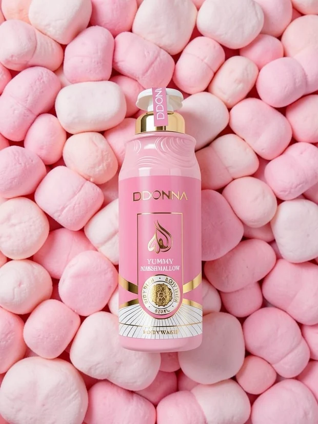 Frasco rosa de bodywash DDONNA sobre muitos marshmallows cor-de-rosa e brancos.