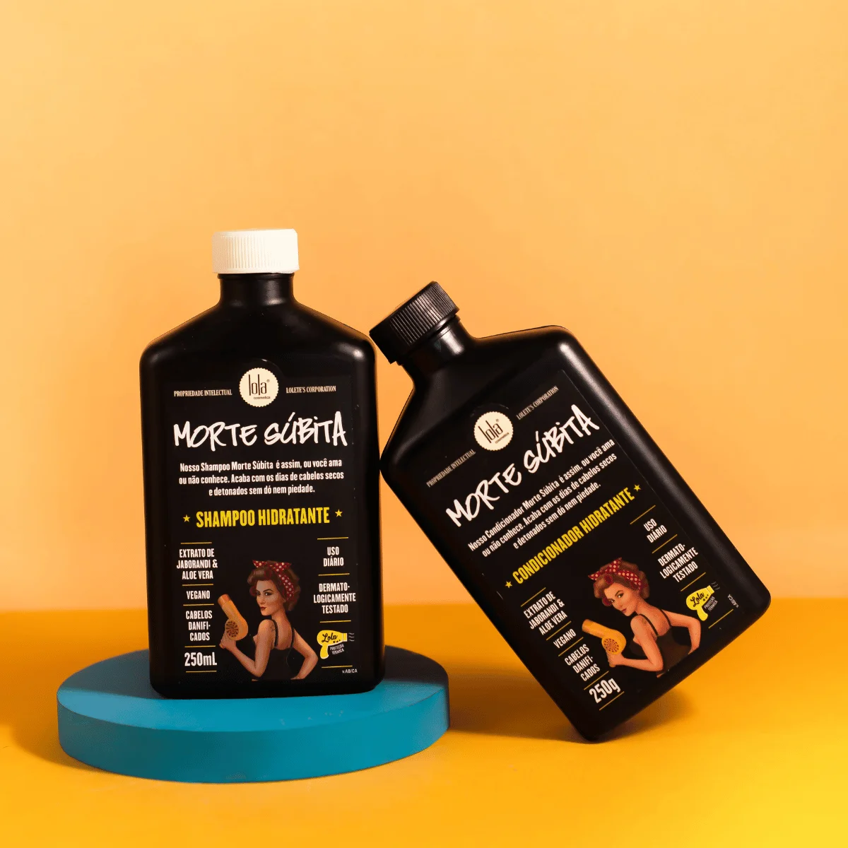 Dois frascos pretos de shampoo e condicionador Morte Subita num fundo amarelo e base azul.