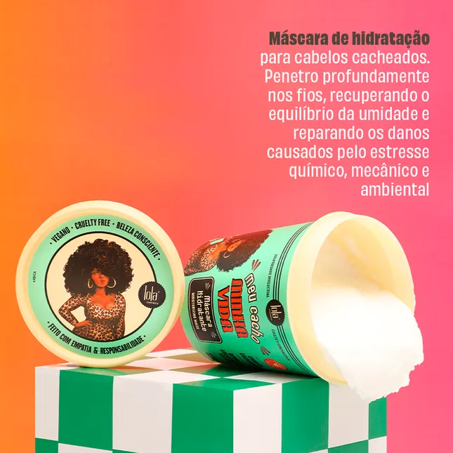 Pote de máscara de hidratação para cabelos cacheados aberto sobre superfície verde e branca com fundo rosa