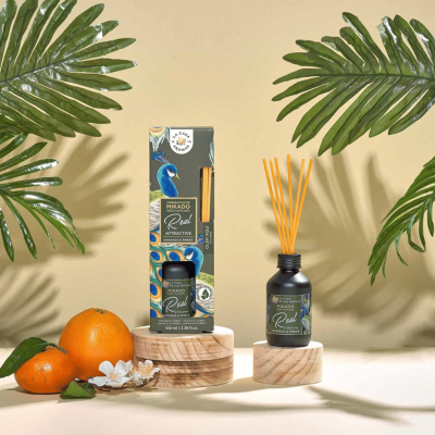 Difusor de aromas Mikado Real Attractive com embalagem e tangerinas em fundo com folhas tropicais
