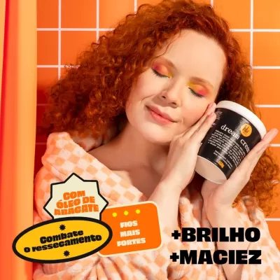 Mulher ruiva segurando pote de creme capilar com texto promocional em fundo laranja