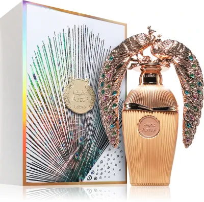 Frasco de perfume dourado com tampa decorada com duas aves e caixa com padrão de penas