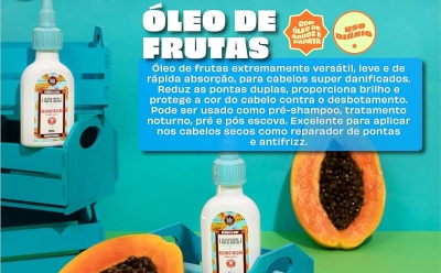 Frascos de óleo de frutas sobre caixa com imagem de papaya e pedaço de mamão papaya.