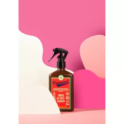 Frasco marrom com pulverizador preto do tónico do crescimento Rapunzel em fundo colorido rosa e branco
