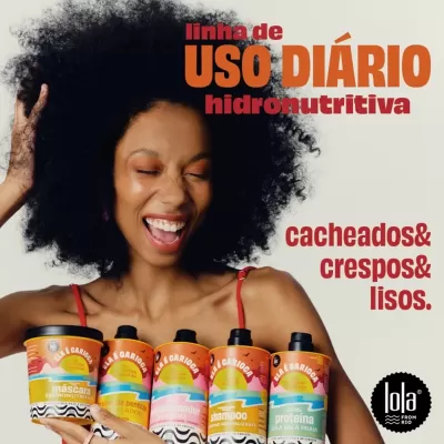 Mulher sorrindo com cinco produtos Lola para cabelo cacheado, crespo e liso em embalagens coloridas.