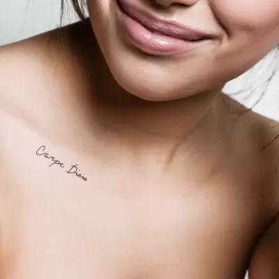Mulher com tatuagem 'Carpe Diem' no ombro esquerdo
