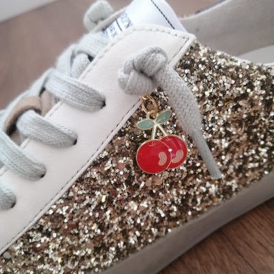 Ténis glitter dourado com atacadores cinza e aplicação de cerejas vermelhas