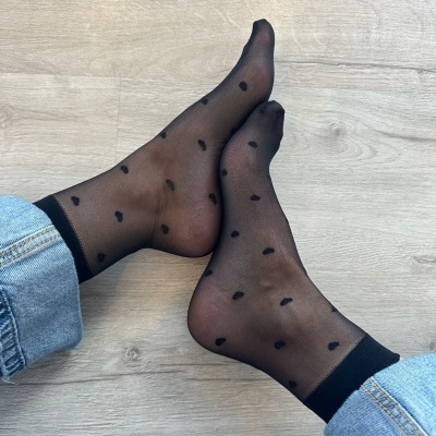 meias pretas transparentes com corações pretos usadas com calças de ganga azul