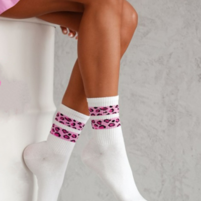 Meias brancas com faixas rosa e padrão de manchas pretas e rosa