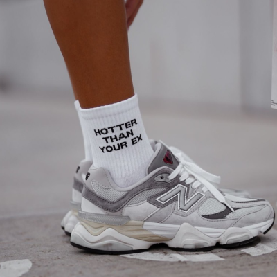 Meia branca com texto preto e ténis cinza branco