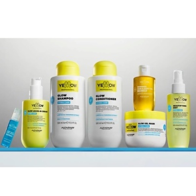 Linha de produtos Yellow Professional da Alfaparf em embalagens amarelas, brancas e transparentes alinhadas numa superfície azul.