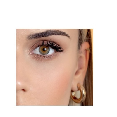 Parte do rosto de mulher com brinco dourado e olho castanho