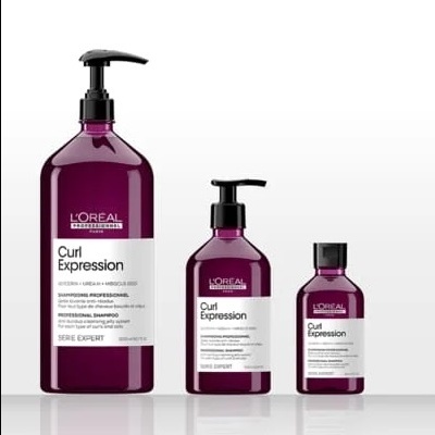 Três frascos roxos do shampoo L'Oréal Curl Expression com tampas pretas em fundo branco