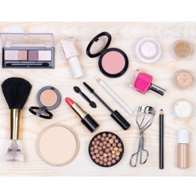 Conjunto de maquilhagem com vários produtos dispostos sobre madeira clara